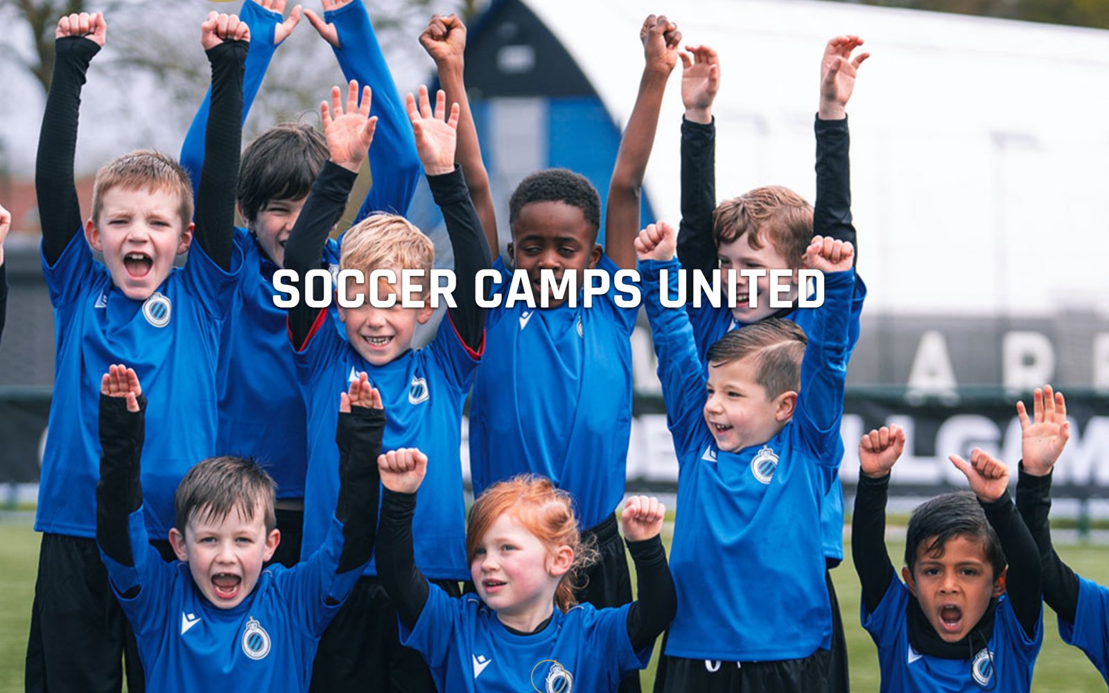 Juichende kinderen in blauwe voetbalshirts met de naam Soccer Camps United